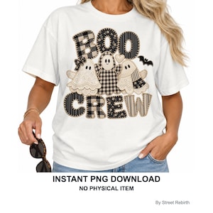 May include: A white t-shirt featuring a graphic design with the text BOO CREW in black and beige plaid and striped patterns. Three ghost figures with lace-like textures and a small black bat are positioned between the words. The design uses a patchwork style.