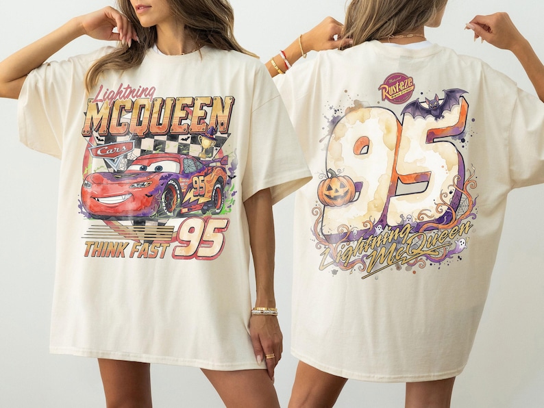 May include: An off-white t-shirt featuring a graphic of Lightning McQueen from Cars on the front with the text Lightning McQueen, Cars, and Think Fast 95. The back displays a large 95 with a pumpkin, a bat, and the text Lightning McQueen.