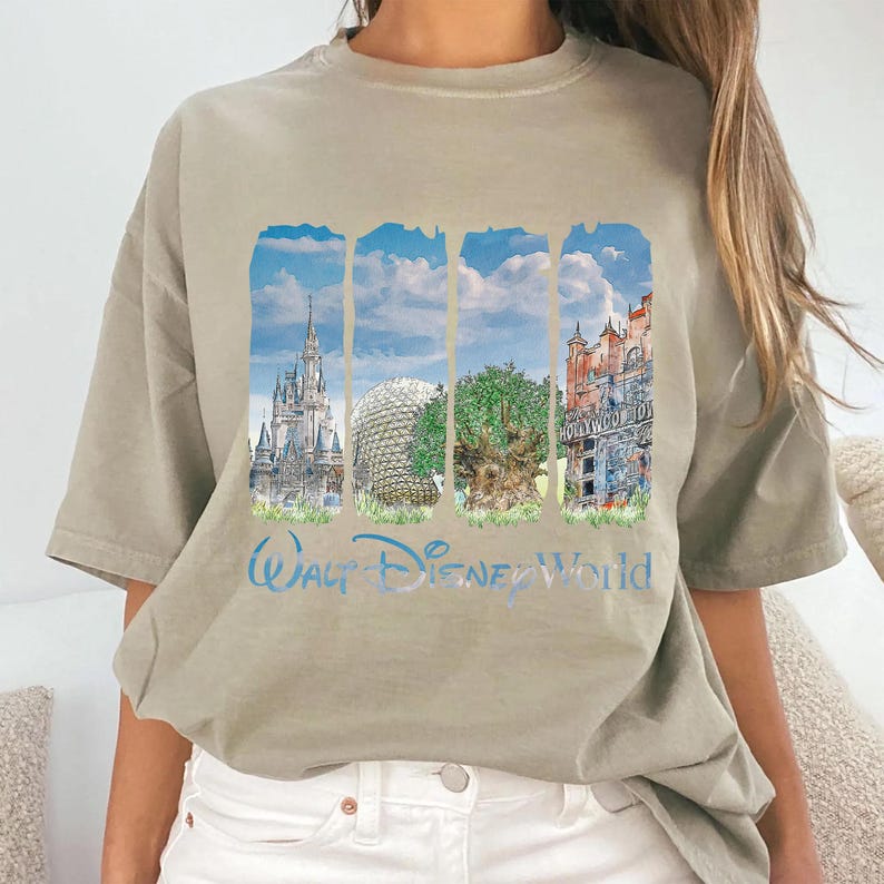 May include: A beige short-sleeve t-shirt featuring a graphic print of four vertical panels depicting Walt Disney World landmarks, including a castle, a geodesic dome, a tree, and a building, with the text Walt Disney World printed below.