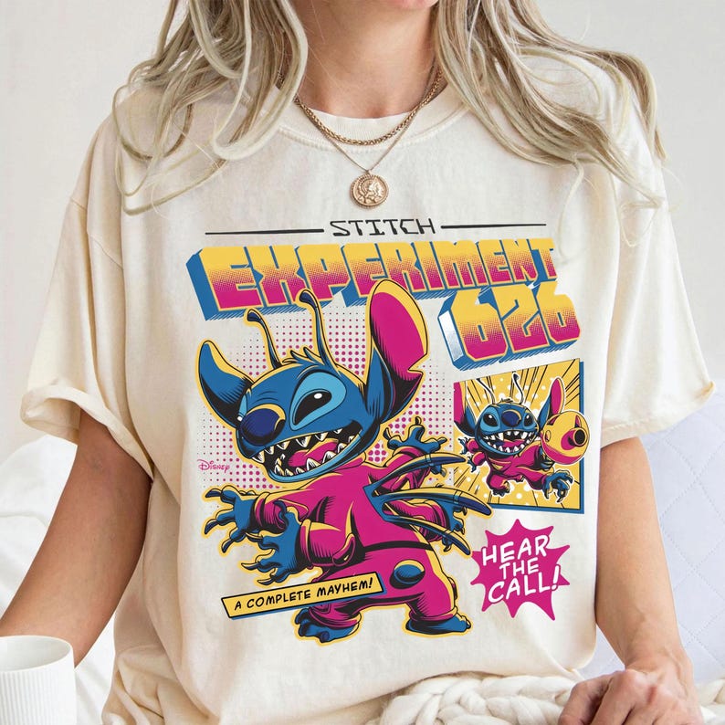 Puede incluir: Camiseta color crema con un gr&aacute;fico colorido de Stitch de Lilo & Stitch. El dise&ntilde;o incluye el texto "Stitch Experiment 626" y "A Complete Mayhem!" en un estilo retro. La imagen tambi&eacute;n incluye un gr&aacute;fico m&aacute;s peque&ntilde;o de Stitch y las palabras "Hear the Call!"