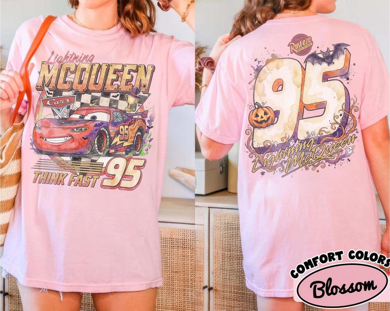 May include: A light pink t-shirt featuring a graphic of Lightning McQueen from Cars on the front with the text Lightning McQueen, Think Fast, and 95. The back displays a large 95 with a pumpkin, a bat, and the text Lightning McQueen.