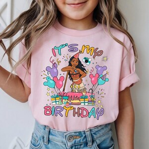K&ouml;nnte beinhalten: Hellrosa T-Shirt mit dem Text "It's my Birthday" und einer Cartoon-Illustration eines M&auml;dchens mit Partyhut. Das Design umfasst Ballons, Geschenke und einen Kuchen, ideal f&uuml;r eine Geburtstagsfeier.