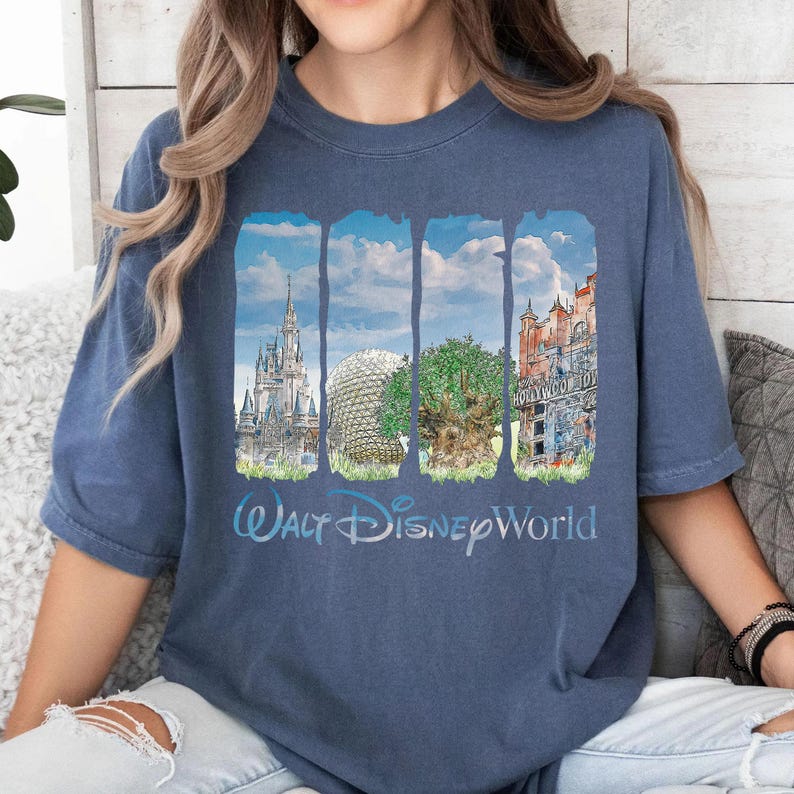 May include: A blue short-sleeve t-shirt featuring a graphic print of four vertical panels displaying iconic Walt Disney World landmarks, including a castle, a geodesic dome, a large tree, and a tower, with the text Walt Disney World below.
