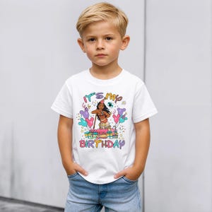 K&ouml;nnte beinhalten: Wei&szlig;es T-Shirt mit einer bunten Grafik einer Zeichentrickfigur und dem Text "It's my birthday". Das Design umfasst Luftballons und eine Geburtstagstorte. Das T-Shirt wird von einem kleinen Kind getragen.