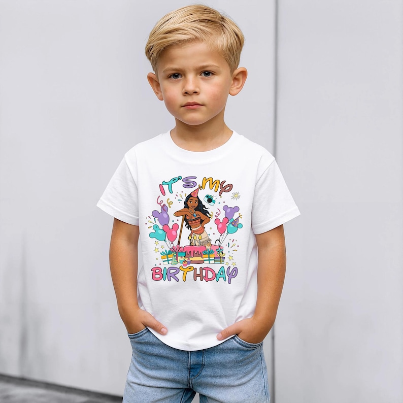 K&ouml;nnte beinhalten: Wei&szlig;es T-Shirt mit einer bunten Grafik einer Zeichentrickfigur und dem Text "It's my birthday". Das Design umfasst Luftballons und eine Geburtstagstorte. Das T-Shirt wird von einem kleinen Kind getragen.
