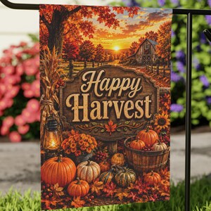 May include: A rectangular garden flag hanging on a black metal stand, featuring a printed autumn scene with a wooden sign that reads Happy Harvest, surrounded by orange pumpkins, a basket, a lantern, and fall foliage under a sunset sky.