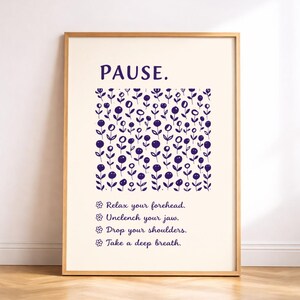 May include: A framed print with the word "PAUSE" in navy blue. Below, a field of navy blue floral illustrations and instructions: "Relax your forehead. Unclench your jaw. Drop your shoulders. Take a deep breath."