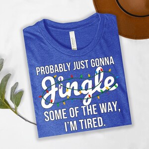 a blue t-shirt with a humorous text printed on it, along with a brown hat and some greenery.