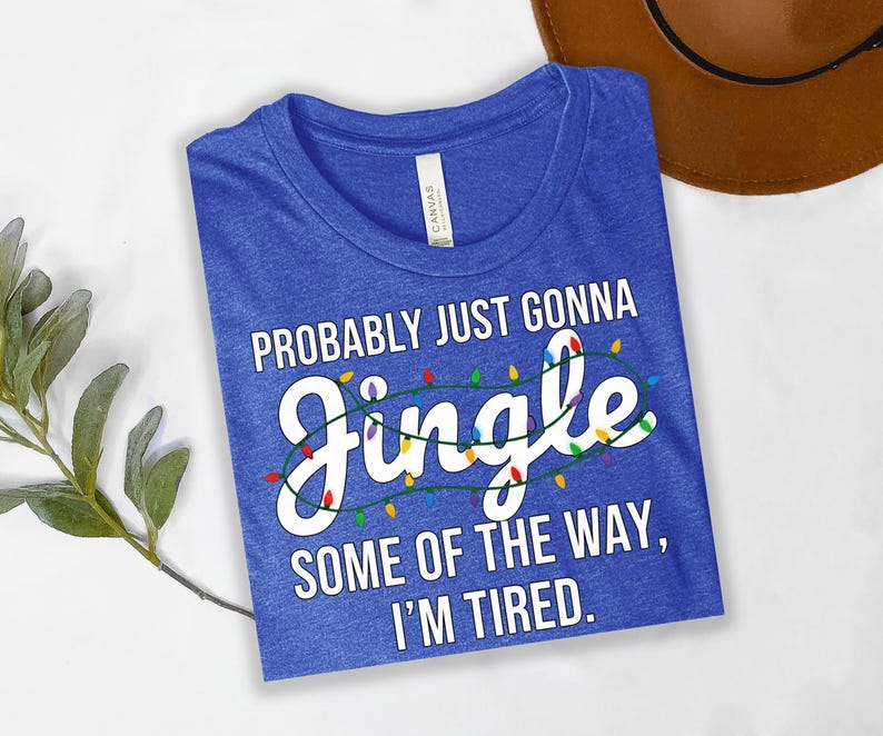 a blue t-shirt with a humorous text printed on it, along with a brown hat and some greenery.