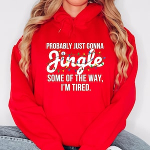 A person wearing a red hoodie with a humorous text printed on it.