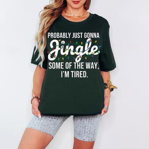 A woman wearing a green t-shirt with a humorous text printed on it.