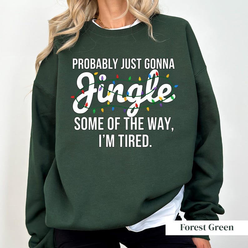 A person wearing a green sweatshirt with a humorous text printed on it.
