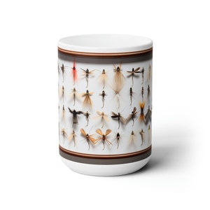 May include: White ceramic mug with a brown border and a pattern of various fly fishing lures. The lures are arranged in rows and are a variety of colors and sizes.