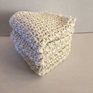 Puede incluir: Un conjunto de tres paños de cocina de ganchillo blanco. Los paños de cocina están hechos de un material suave y absorbente, ideales para limpiar platos, limpiar derrames y secar las manos.
