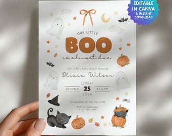 Op de afbeelding: Een witte uitnodigingskaart voor een babyshower met aquarelillustraties van spoken, pompoenen, een zwarte kat en een strik. De tekst luidt Our Little Boo is almost due, Olivia Wilson, Sunday October 25 2026 at 2 PM, inclusief adresgegevens.