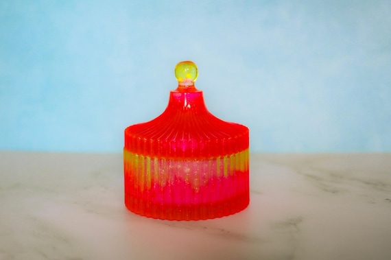Swirling neon resin in pink and orange makes this trinket box look like a tiny art object — not your grandma's jewelry dish.