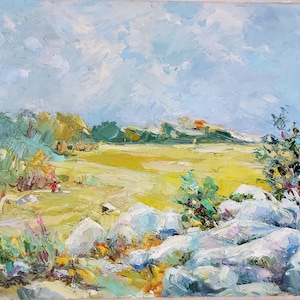 May include: Oil painting depicting a landscape with a yellow field, blue sky, and white rocks in the foreground. The artwork features visible brushstrokes and a textured finish. Trees and bushes are in the background.