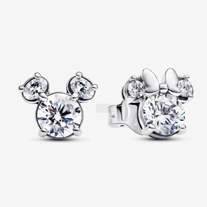 May include: A pair of silver stud earrings. One earring features a Mickey Mouse design with a large, round, clear crystal center and two smaller, pear-shaped crystals. The other earring has a Minnie Mouse design with a bow.