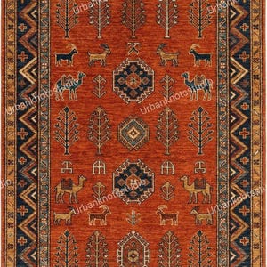 May include: A rectangular, rust-colored rug with a detailed geometric pattern. The rug features a central field with repeating tree and animal motifs, framed by a navy blue border with intricate designs. The rug's dimensions are not visible.