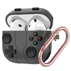 Puede incluir: Una funda protectora gris para auriculares inalámbricos, diseñada para parecerse a un mando de videojuegos. La funda presenta un panel direccional, botones y un mosquetón de oro rosa para sujetar.