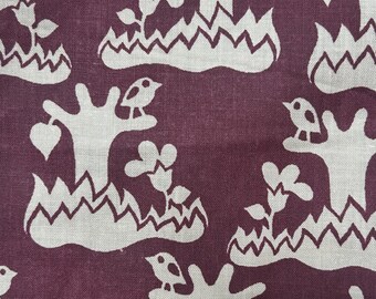 May include: A fabric featuring a repeating pattern of off-white stylized trees, small birds, and flowers set against a deep plum purple background. The design includes jagged, mountain-like shapes at the base of each tree, creating a consistent motif.