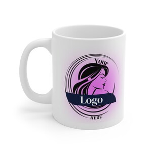 Puede incluir: Taza de cerámica blanca con asa curva. La taza presenta un diseño con la silueta de una mujer, cabello negro y las palabras "Your Logo Here" en un círculo con un fondo degradado rosa y una pancarta azul marino.