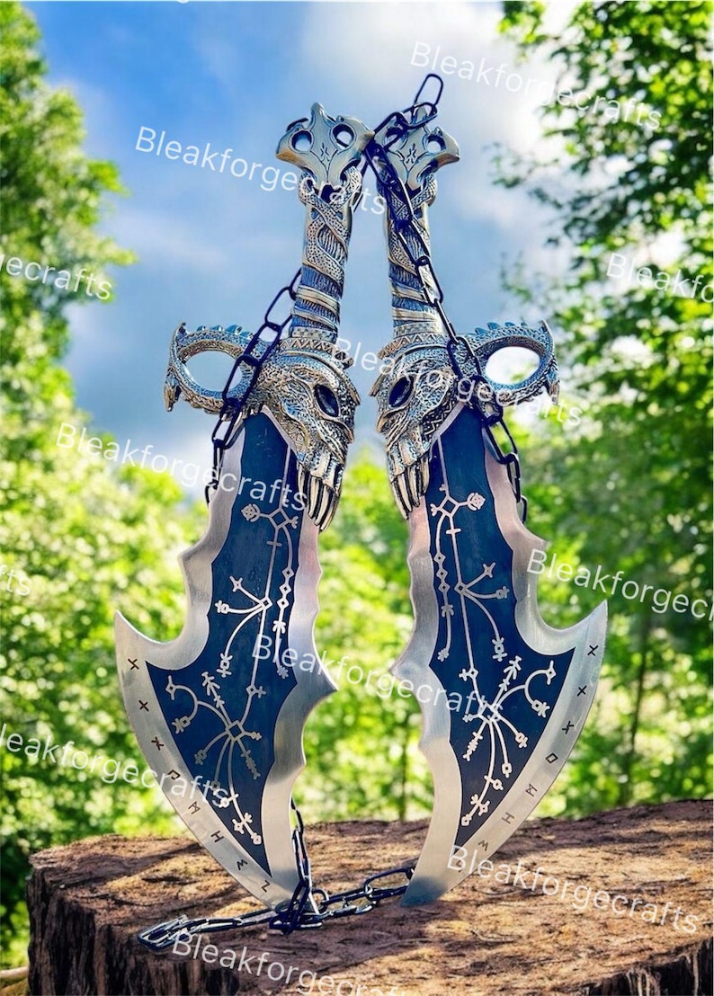 May include: Two silver and blue fantasy blades with intricate designs and a chain connecting them. The blades have a skull-like design on the hilt and are set against a natural background.