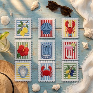 May include: A set of nine square coasters with scalloped edges, each featuring embroidered designs including lemons, a seashell, a lobster, a hibiscus flower, sardines, a cocktail, an oyster, a crab, and olives on striped backgrounds.