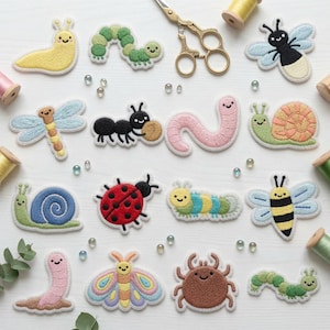 May include: A collection of embroidered insect and garden creature patches including a yellow slug, green caterpillars, a dragonfly, an ant, a pink worm, snails, a ladybug, a bee, a butterfly, and a brown beetle, arranged with scissors and thread.