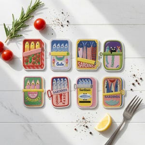 May include: Eight rectangular embroidered patches featuring colorful sardine tin designs. Each patch displays stylized fish illustrations, some with text reading Sardines, Quite, or Original Sardines, and one featuring a small black cat graphic.
