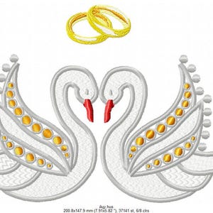 May include: An embroidered design featuring two white swans facing each other, with red beaks and gold accents. Above the swans are two gold wedding rings. The design is on a white background.