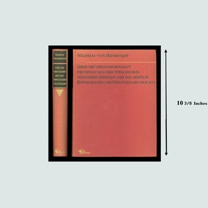May include: A vintage book with a red cover and spine. The title "Über die Verschiedenheit des menschlichen Sprachbaues und ihren Einfluss auf die geistige Entwicklung des Menschengeschlechts" is printed on the cover. The book is approximately 26.35 cm tall.