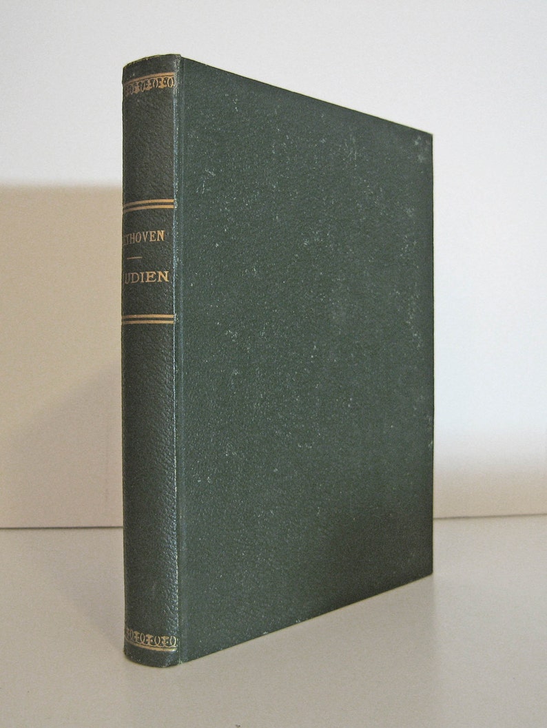May include: A hardcover book with a dark green cover and spine. The spine features gold lettering that reads "Beethoven - Studien". The book is standing upright on a white surface.