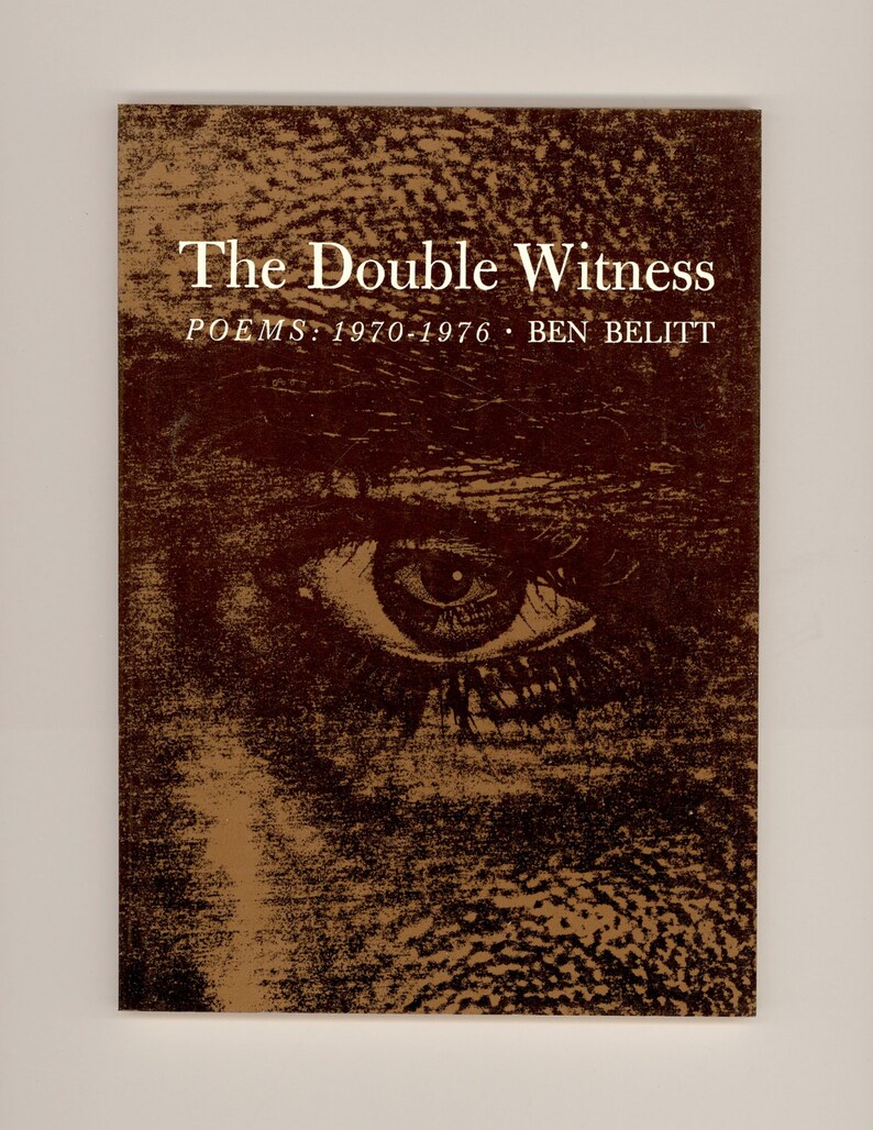 May include: A book cover with a brown background and a close-up of an eye. The title of the book is "The Double Witness: Poems 1970-1976 - Ben Belitt".