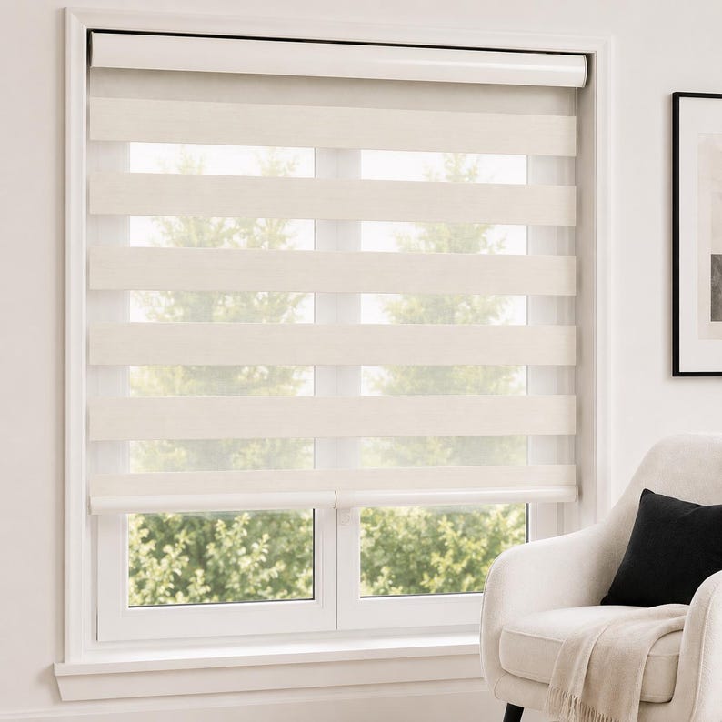 Pu&ograve; includere: Una tenda a rullo a doppio strato con bande orizzontali alternate di tessuto solido color bianco sporco e materiale a rete trasparente. La tenda &egrave; montata all'interno di un telaio bianco, lasciando filtrare la luce attraverso le sezioni.