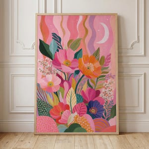 May include: A rectangular wall art print in a light wood frame featuring a vibrant floral illustration. The artwork displays pink, orange, and purple flowers with green foliage against a wavy pink background with a white crescent moon and stars.
