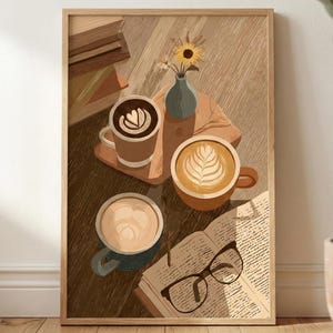 May include: A framed art print depicts a cozy coffee scene. Three mugs of coffee with latte art sit on a wooden surface, alongside an open book and glasses. A small vase with flowers adds a touch of nature. The color palette is warm and inviting.