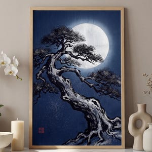 May include: A framed print of a Japanese-style painting featuring a bonsai tree silhouetted against a full moon in a dark blue sky. The artwork has a wooden frame and is displayed on a marble surface with decorative items.