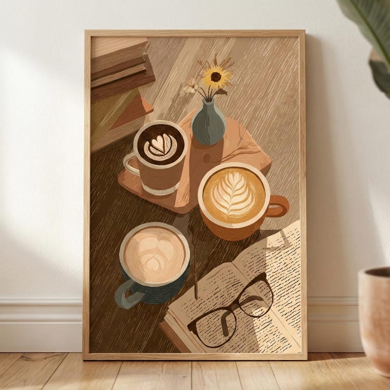 May include: A framed art print depicts a cozy coffee scene. Three mugs of coffee with latte art sit on a wooden surface, alongside an open book and glasses. A small vase with flowers adds a touch of nature. The color palette is warm and inviting.