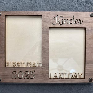 Może przedstawiać: Drewniana ramka na zdjęcia z dwoma otworami. Ramka jest wygrawerowana słowem "Kinder" oraz frazami "First Day" i "Last Day" wraz z rokiem "2025". Ramka jest utrzymywana razem za pomocą czterech metalowych nitów.