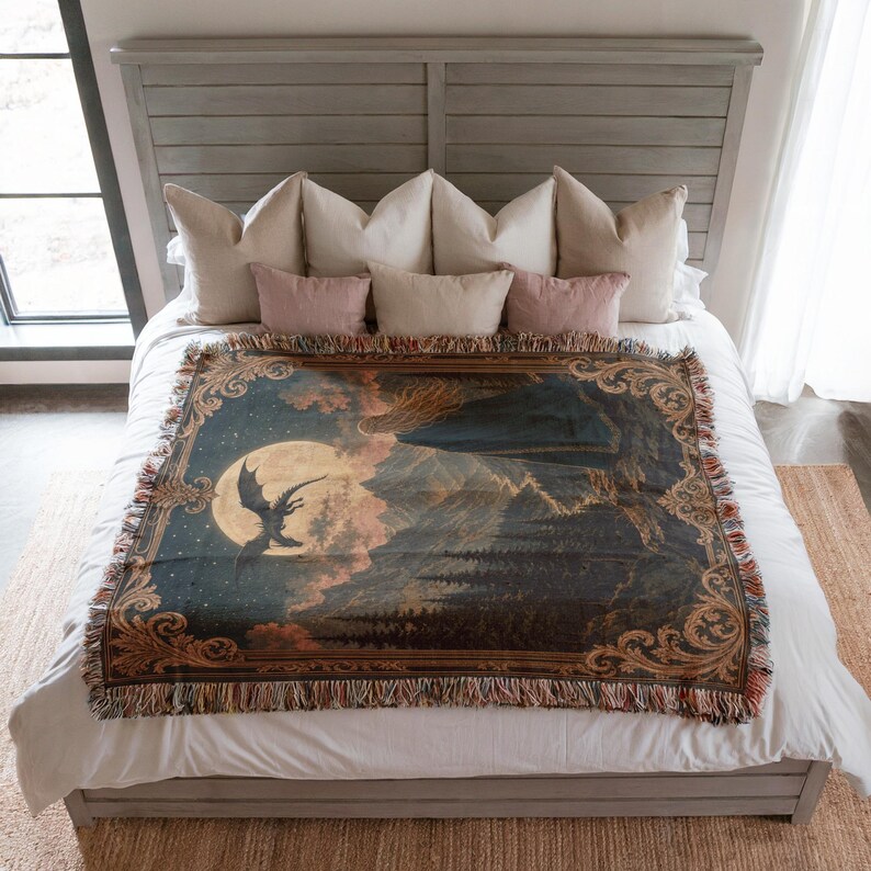 Woven throw depicting a woman looking at a dragon flying towards the moon over a mountain landscape.