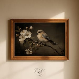 May include: A framed painting of a small bird perched on a branch with white blossoms. The bird has blue and gray feathers. The painting is in a wooden frame and is set against a dark background.