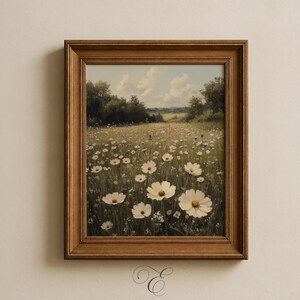 May include: A framed landscape painting shows a field of white flowers under a blue sky with clouds. The artwork is set in a warm-toned wooden frame, creating a vintage aesthetic. The painting evokes a sense of tranquility and natural beauty.