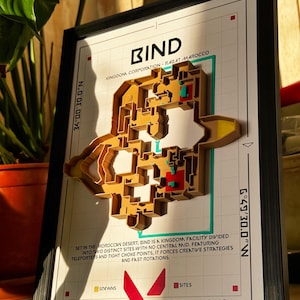 Puede incluir: Obra de arte enmarcada con un mapa 3D de la ubicación "Bind", con el texto "Bind Kingdom Corporation Rabat Marocco". El mapa es en tonos marrones, verdes y rojos, sobre un fondo blanco. El marco es negro.