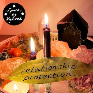 Puede incluir: Una colección de cristales que incluye cuarzo rosa, una piedra naranja y una gran punta de obsidiana negra, dispuesta con dos velas de color morado oscuro encendidas y una hoja verde con el texto "relationship protection". Logo "Spells by Velvet".