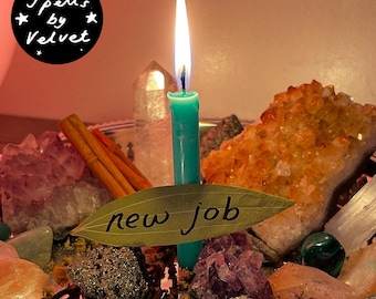 Könnte beinhalten: Eine türkisfarbene Kerze mit brennender Flamme steht inmitten verschiedener Kristalle, darunter eine große orangefarbene Citrin-Stufe, violetter Amethyst und klarer Quarz. Ein Lorbeerblatt mit der schwarzen Aufschrift "new job" liegt vor der Kerze.