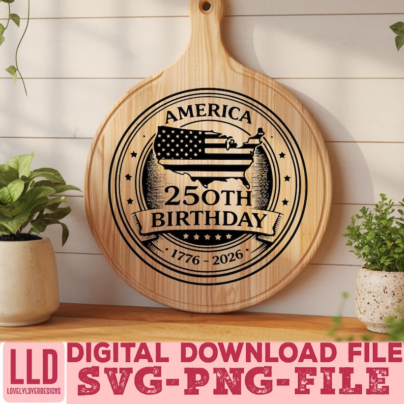 May include: A round wooden cutting board with a handle, featuring a black and white design commemorating America's 250th birthday. The design includes the American flag within a map outline, stars, and the years 1776-2026.