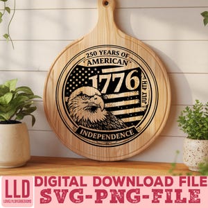 May include: A round wooden cutting board with a handle, featuring a black and white graphic commemorating 250 years of American Independence. The design includes an eagle, the year 1776, and the American flag. The text "July 4th" and "Independence" are also included.