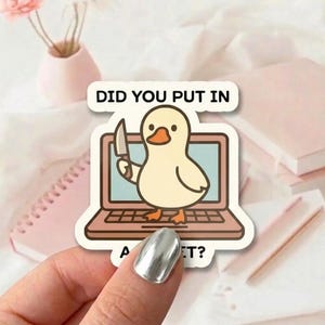 May include: A sticker with a cartoon duck holding a knife, positioned in front of a laptop screen. The text on the sticker says "DID YOU PUT IN A... ?" in a playful font. The duck is light yellow with an orange beak.