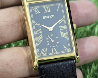 Orologio da polso giapponese vintage Seiko al quarzo con secondi intermedi e quadrante nero, numeri romani, ricondizionato.
